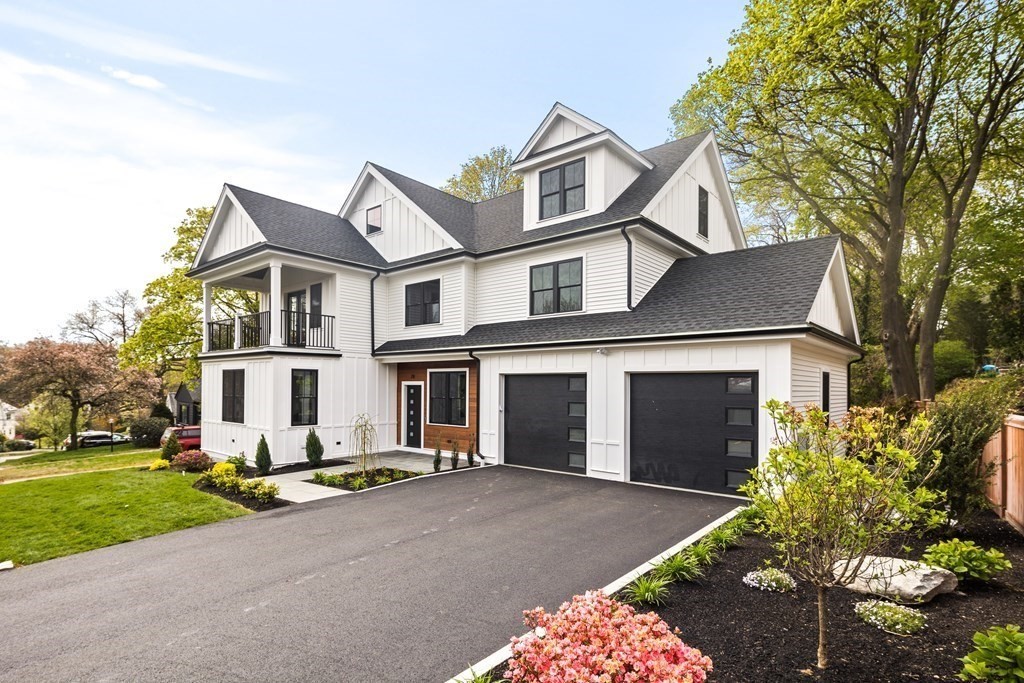 A modern farmhouse steps to Lower Mystic Lake, this Arlington stunner affords 6,000-SF of light-soaked luxury. The quintessence of curb appeal, the 6BD, 6.5BA abode features a slat-paneled portico and 2nd floor balcony. Cuing up high-end finishes & impeccable craftsmanship, the open-concept seamlessly merges living/dining/kitchen. Elevated by custom built-ins & a stone fireplace, a cozy living room is joined by a formal dining area. Decked in quartz counters & S/S appliances, a striking kitchen features shaker-style cabinets & colossal island. Finished by a half-bath & mud room, a lavish guest suite perfect for visiting in-laws. A departure from the everyday, the primary suite boasts walk-in closet, balcony w/ lake views, and ensuite bath. The 2nd floor houses laundry, 3 bedrooms and 2 full baths. At the 3rd floor, a rec room is joined by a bedroom & office. The basement houses a rec room, half-bath, and extra storage. Equipped w/ a 2-car garage, the back patio is fenced for privacy.