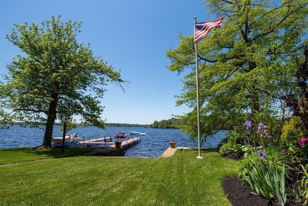 Welcome home to your waterfront, wooded retreat on the largest fully-recreational lake in MA! The perfect location situated equidistant between Boston and Providence (~45 mins) and half an hour from Cape Cod with a Boston commuter rail station right in town. Why spend hours traveling to get away when you can live in your year-round vacation home! From the moment you turn down the freshly-paved long, winding driveway through the idyllic one-acre wooded lot, you will feel like you are in another world. This beautifully landscaped three bedroom (plus two bonus rooms!), two bath, waterfront home with additional entertaining kitchen/living area and detached, oversized two-car garage with great room features breathtaking views of Long Pond and afternoon sunsets. Thoughtfully updated with custom finishes over the years by the long-time owners featuring a brand new 3-bed septic system and roof. NO flood insurance required!