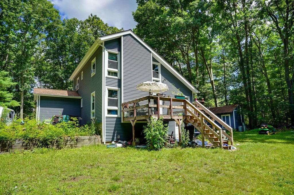 Contemporary Cape on private wooded lot. Large open living and dining space with cathedral ceiling. Ceiling is wood. Kitchen fully appliance.  First floor bath. First floor bedroom.Second floor with 2 bedrooms and bath. Access to deck from main room.
